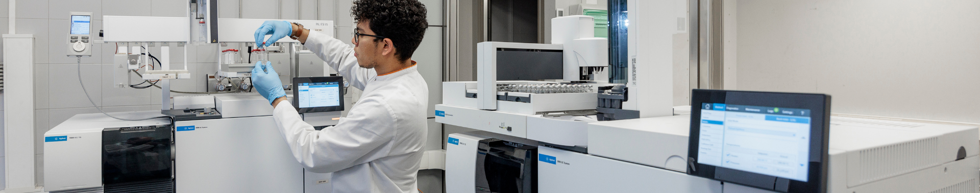Un técnico de laboratorio en un laboratorio moderno y bien equipado de Eurofins BioPharma Product Testing, observando atentamente el monitor de un ordenador con análisis de datos. El ambiente de trabajo es limpio y organizado, con equipos de alta tecnología y herramientas especializadas utilizadas para la validación de instalaciones y procesos, asegurando la precisión y confiabilidad de los resultados en el sector farmacéutico.